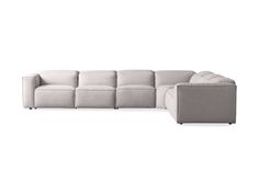 a white sectional couch sitting on top of a white floor next to a gray chair