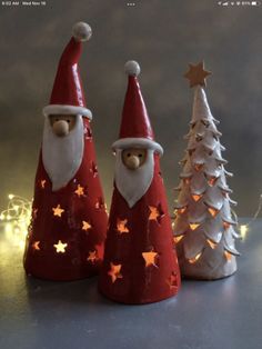 three christmas trees with santa hats and stars on them, one is white and the other is red