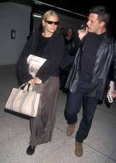 a man and woman walking through an airport