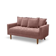 a pink couch with four pillows on the back and two arms, in front of a white background