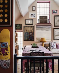 a living room filled with furniture and lots of pictures on the wall next to a table