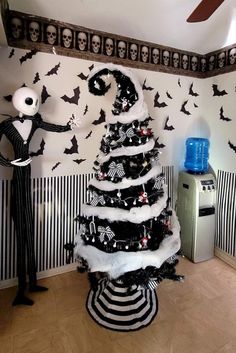 a black and white christmas tree in a room with bats on the wall behind it