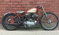 an old motorcycle parked in front of a brick wall