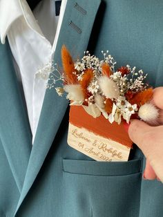 a person in a blue suit is holding something with feathers and flowers attached to it