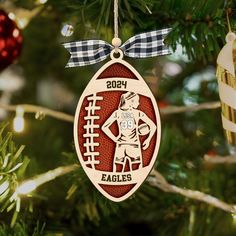 a football ornament hanging from a christmas tree