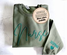 a green sweatshirt with the word nurse on it