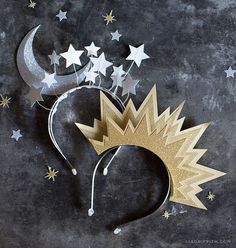 a paper crown with stars and moon on it's side, next to a crescent