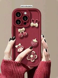 a woman holding up a red phone case with buttons on the front and back of it