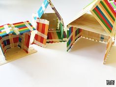 three different colored paper houses sitting next to each other