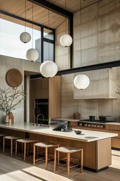 an open kitchen with wooden cabinets and white counter tops, along with hanging lights above the island