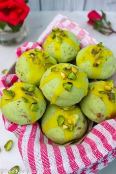 a bowl filled with green and yellow desserts on top of a red and white towel