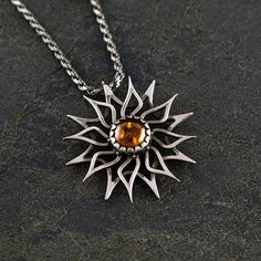 SUN pendant made of 925 sterling silver with an oxide and matte finish. Designed in 3D and finished in our workshop. In the center there is a natural stone of 8 millimeters in diameter. The total diameter of the sun (end to end) is 30 millimeters. The sun is hanging from a silver chain with 50 cm lenght.  The Sun, the luminous star. It symbolizes our maximum power, the capacity to love and marks the path to expand the inner consciousness. The Sun symbolizes above all the source of light that allows life. Thus it provides vital energy, heat and allows all organisms to grow and manifest. Sterling Silver Necklace With Sun Design, Silver Sterling Silver Necklace With Sun Design, Sterling Silver Sun Design Spiritual Necklace, Hand Forged Amber Sterling Silver Jewelry, Sterling Silver Sunburst Jewelry With Sun Design, Sterling Silver Sunburst Jewelry, Sterling Silver Jewelry With Sun Design, Silver Sunburst Jewelry For Gifts, Silver Sunburst Necklace For Gift