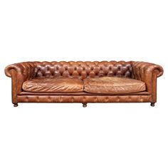 a brown leather couch with buttons on the back and arm rests against a white background