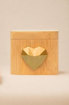 an origami heart on a wooden box