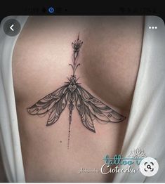 the back of a woman's shoulder with a dragon tattoo on it, and an arrow