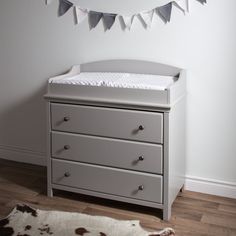 a baby crib in the corner of a room with a cow rug on the floor