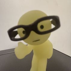 a small plastic figure with glasses on it's head