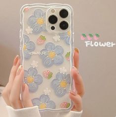 a woman is holding up her phone case with flowers on the front and back cover