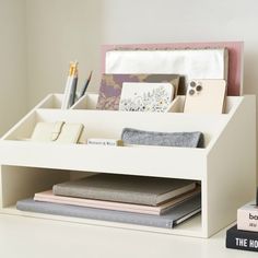 a white desk with books, notebooks and pens