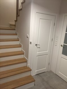 an empty room with white doors and stairs