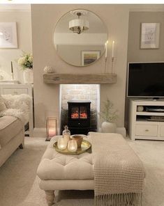 a living room filled with furniture and a fire place next to a tv mounted on a wall