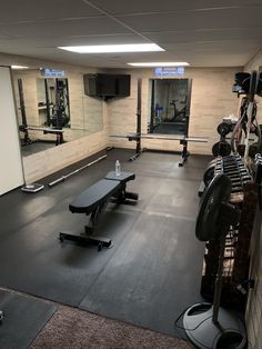 an empty gym with benches, mirrors and exercise equipment on the floor in front of them