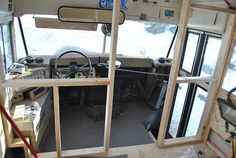 the inside of a boat with windows and steering wheel