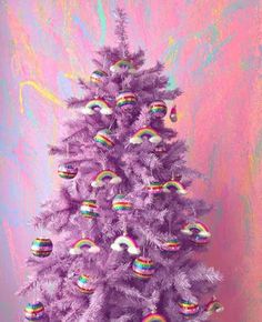 a purple christmas tree decorated with rainbow ornaments