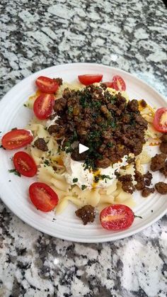 a white plate topped with pasta and meat