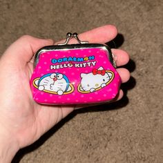 someone holding a hello kitty coin purse in their hand