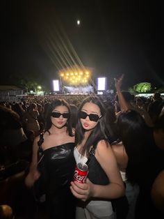 two women standing next to each other at a concert