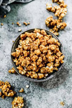 a bowl filled with caramel popcorn on top of a table next to a napkin