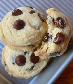 three chocolate chip cookies sitting on top of a pan