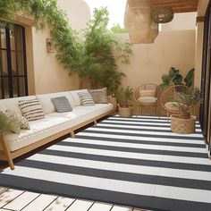 an outdoor living area with couches and potted plants