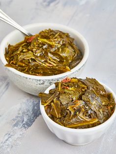 two white bowls filled with food on top of a table