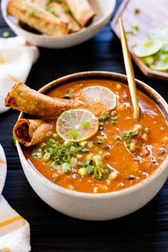 a bowl filled with soup and garnished with limes