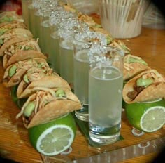 a wooden table topped with lots of food and drink glasses filled with drinks next to each other