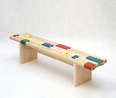 a bench made out of wooden sticks with colored handles