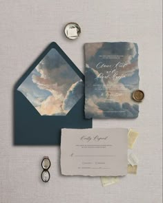 the wedding stationery is set up with an envelope, wax stamp and some other items