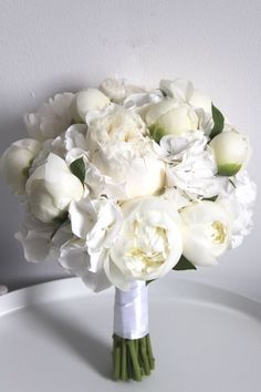 a bouquet of white flowers sitting on top of a table