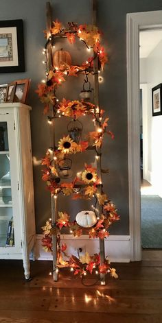 a ladder decorated with fall leaves and lights