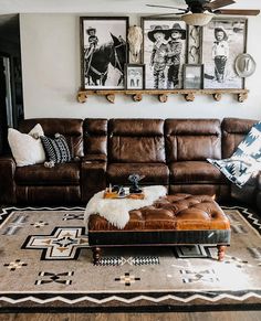 a living room with brown leather couches and pictures on the wall above it's coffee table