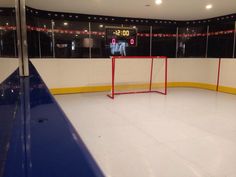 an indoor hockey rink with a goal and scoreboard