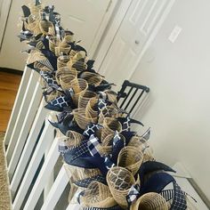 several wreaths with blue and white ribbons are lined up on a stair case in front of a door