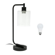 a black table lamp with a clear glass shade on it and a light bulb attached to the base