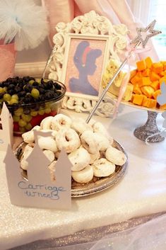 a table topped with lots of different types of food next to a framed picture on top of a wall