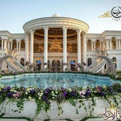 an elaborately decorated fountain in front of a large white building with columns and arches