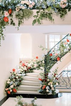 a staircase decorated with flowers and greenery