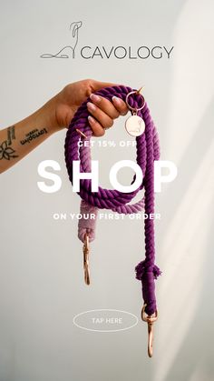 a hand holding a purple rope with the words shop on it