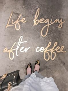 a woman's feet and purse sitting on the ground with words painted on it